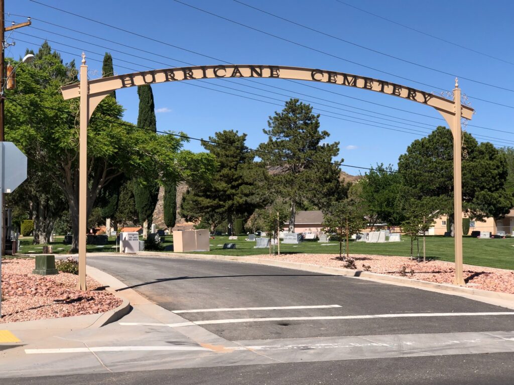 Arched Hurricane Cemetery entrance sign with dark lettering and decorative metal scrollwork